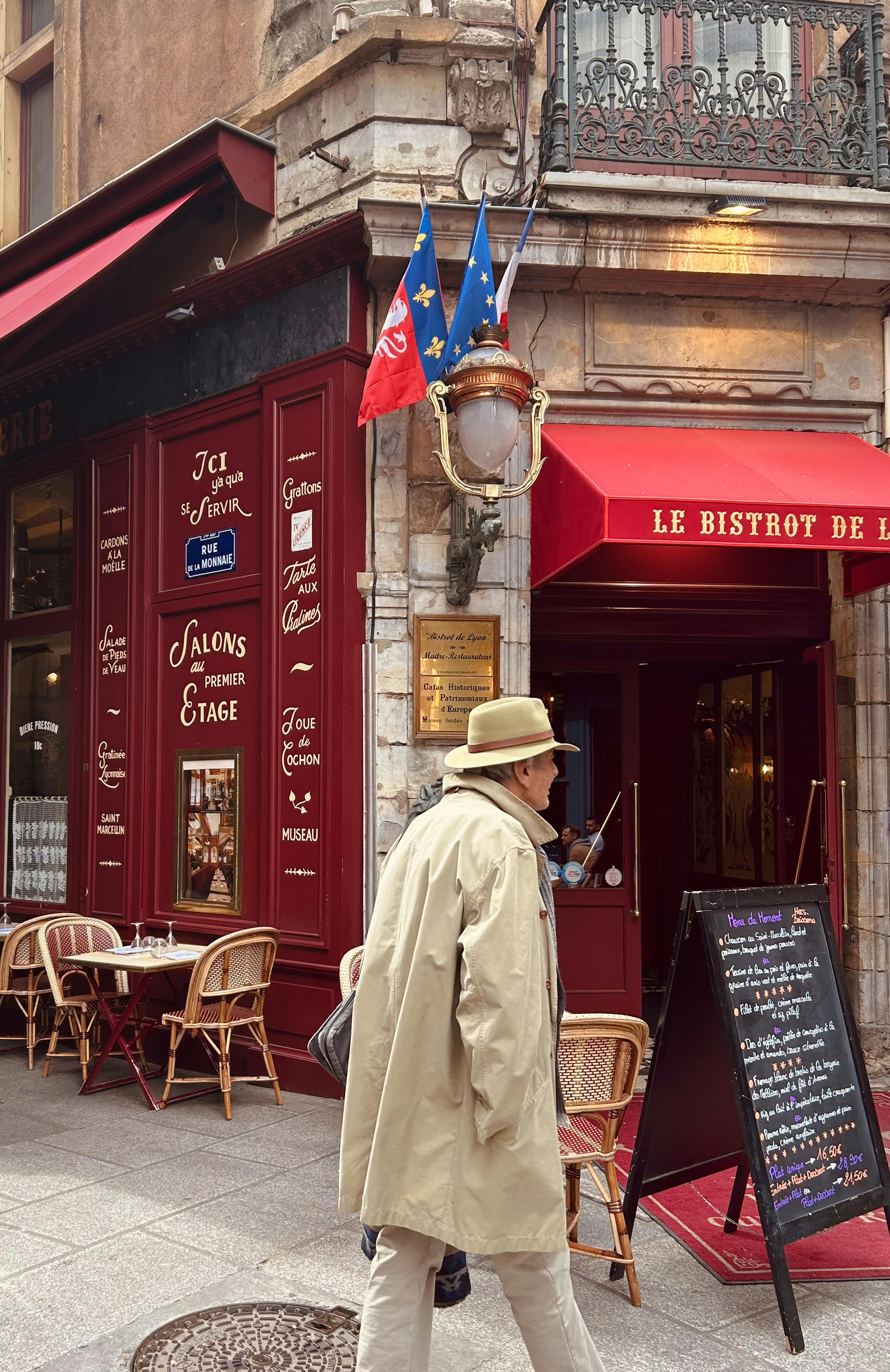 Vintage French bistro with outdoor seating and classic architecture in Lyon, France.