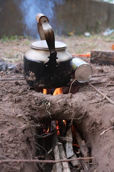Rustic outdoor setup with kettle on fire in Cambodian countryside.