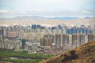 Explore the urban skyline of Ulaanbaatar, Mongolia with mountains in the backdrop.