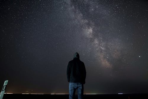 Free Unrecognizable man standing under starry sky Stock Photo