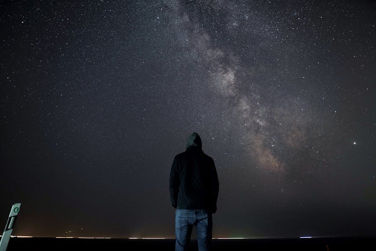 Unrecognizable Man Standing Under Starry Sky