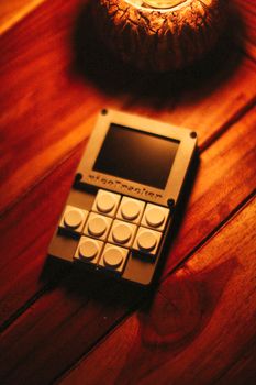 A compact electronic gadget displayed on a warm-toned wooden table under cozy lighting.