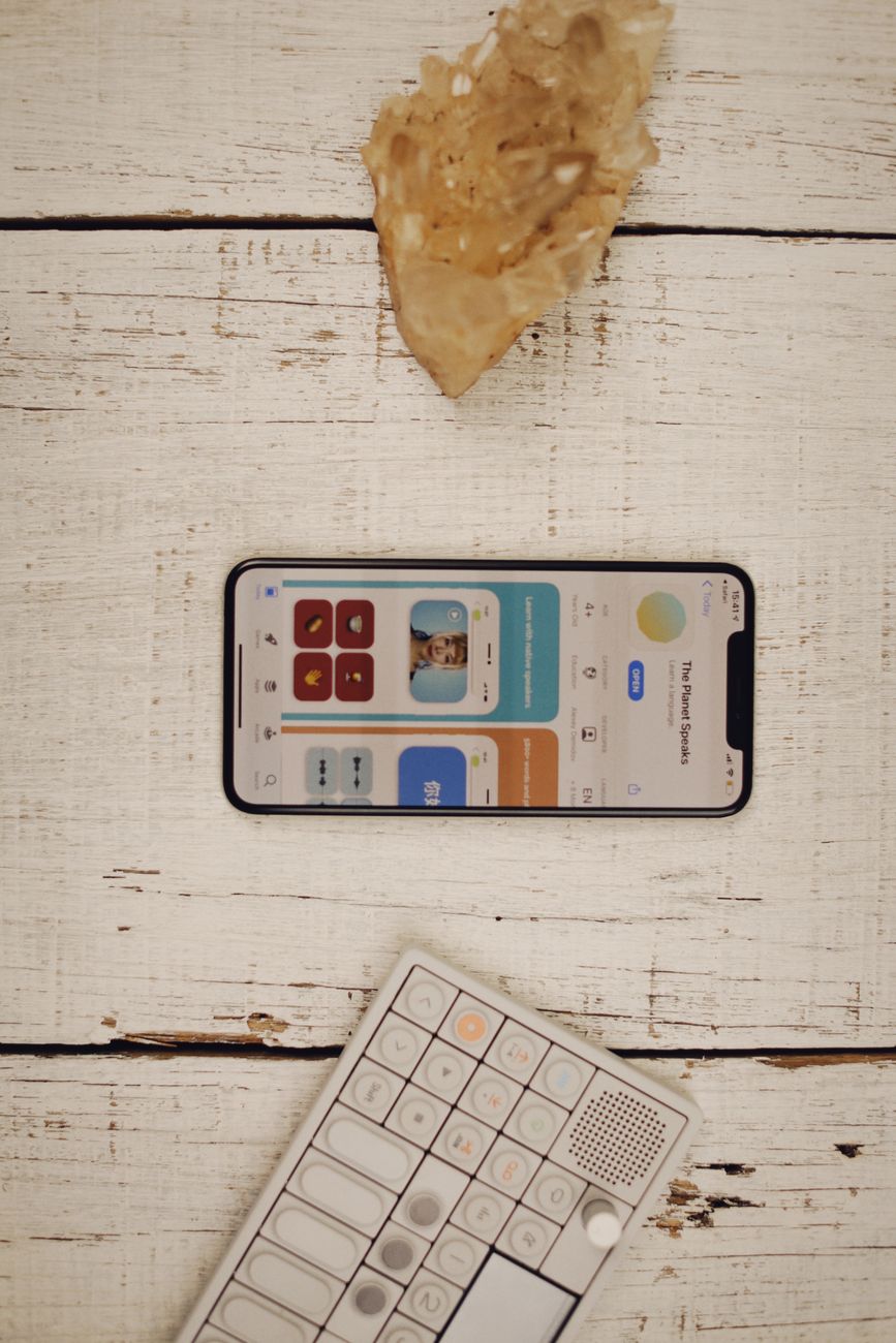 Top view of a smartphone and keyboard on a rustic white wooden background