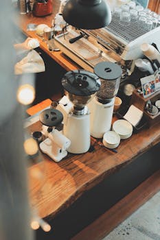 Aesthetic view of a café countertop in Hanoi, Vietnam, featuring coffee grinders and cups.