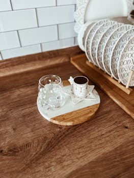 Cozy kitchen counter with coffee cup and glass in rustic setting.