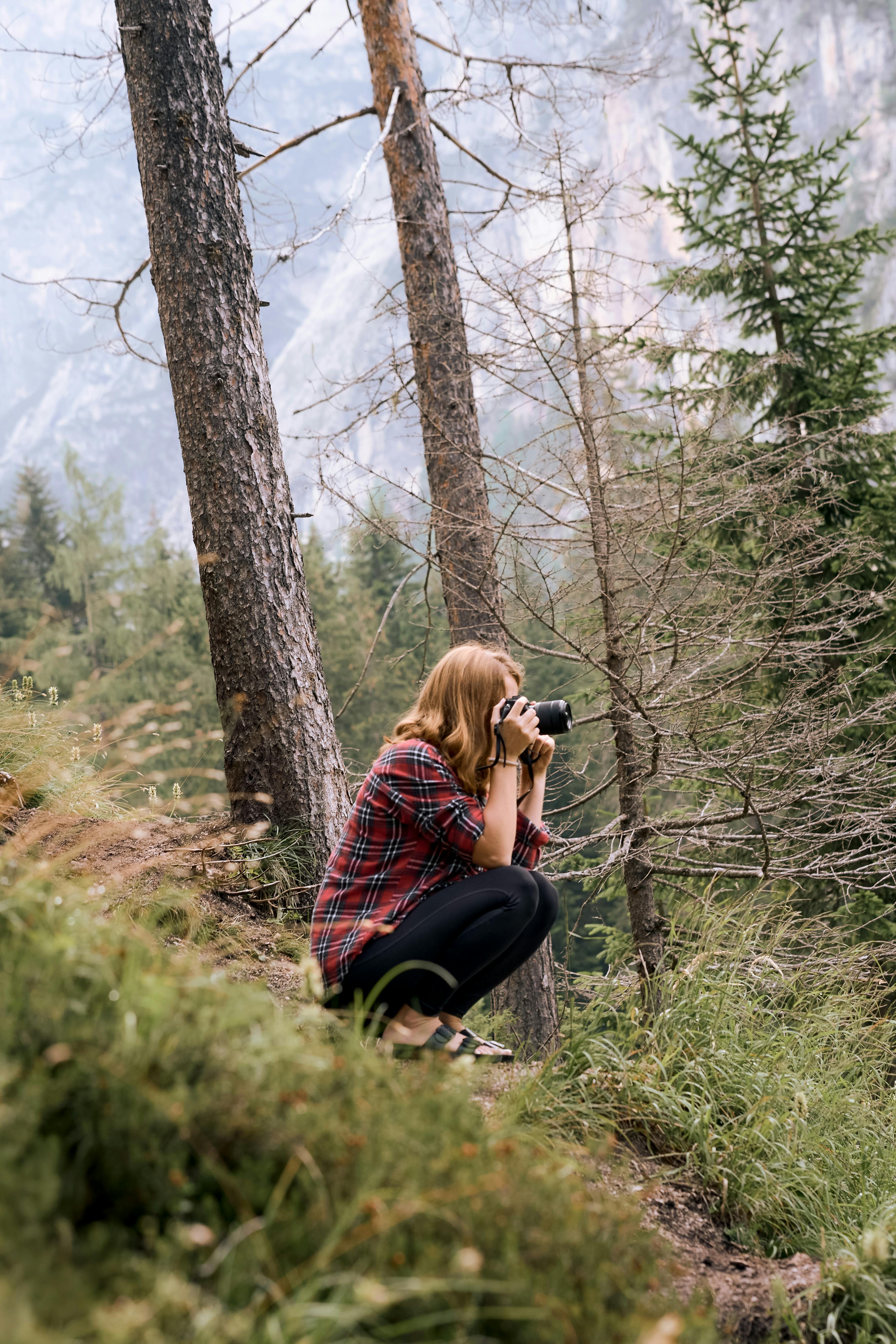 Young photographer capturing nature moments in a scenic forest.