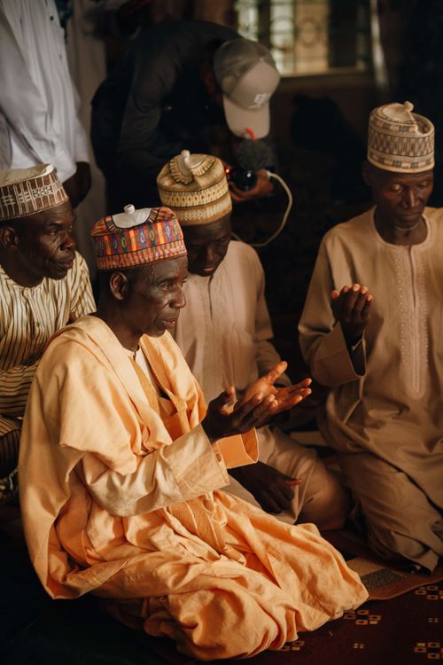 Free Group of men in traditional clothing participating in a cultural event indoors. Stock Photo