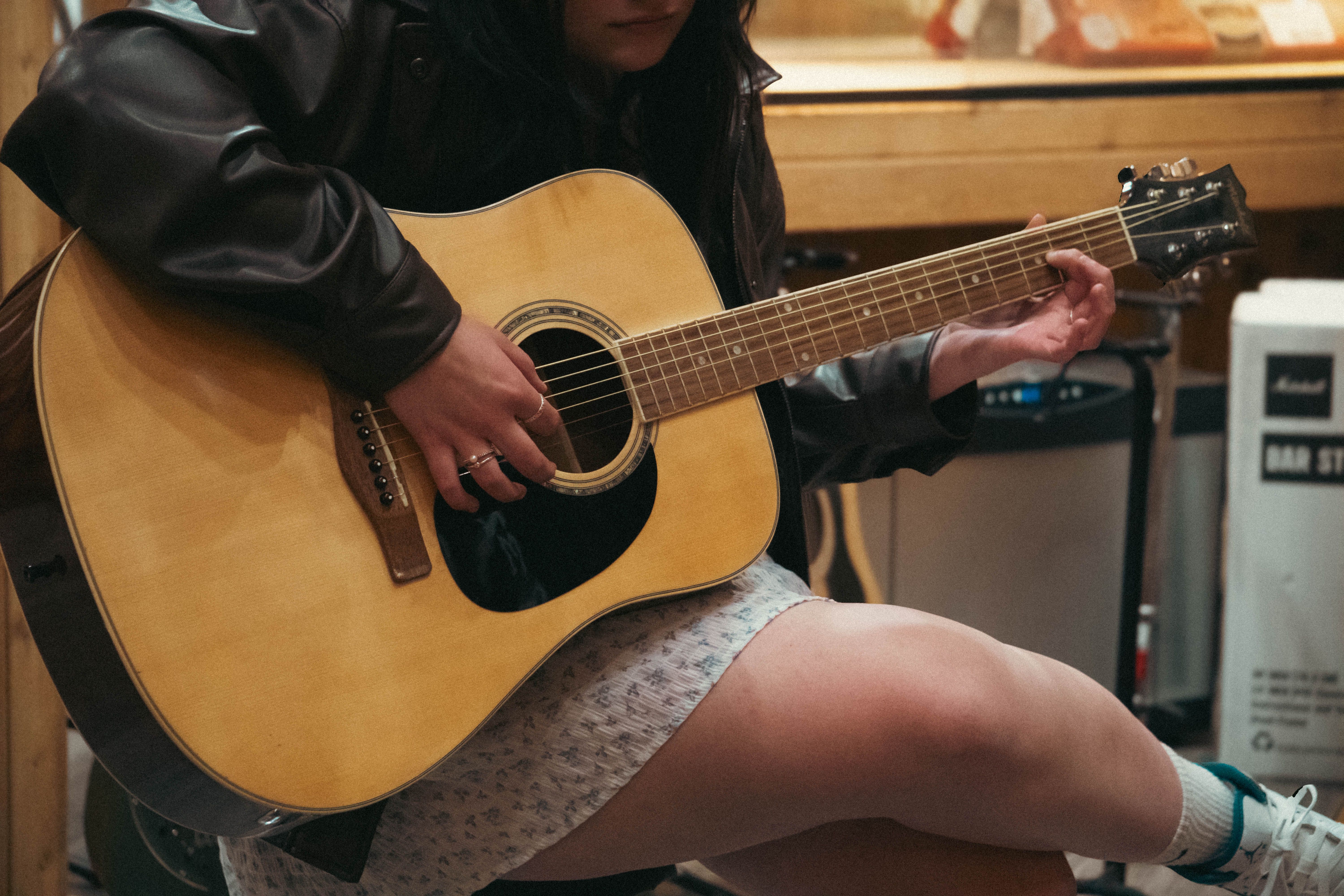 Young Woman Playing Acoustic Guitar Indoors · Free Stock Photo