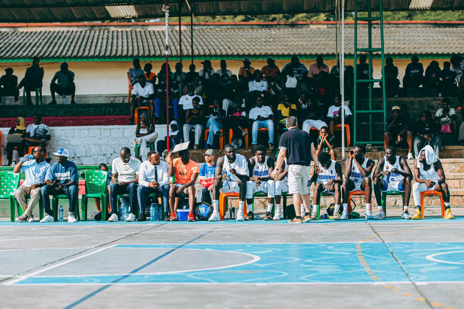Equipe de basquete reunida em roda para conversar durante intervalo de jogo ao ar livre