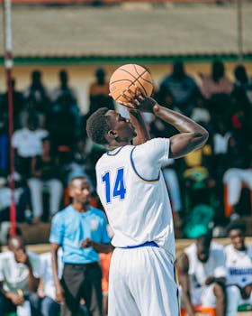 A basketball player in action, mid-shot during an outdoor game. Vibrant and dynamic sports scene.