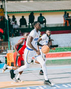 Dynamic basketball scene with players in action on outdoor court.