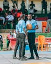 Basketball Referees Discuss Game Strategy Courtside