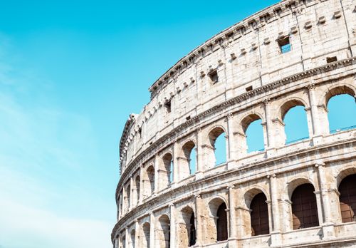 Free The Colosseum in Rome, Italy, stands prominent against a clear blue sky, showcasing its historical grandeur. Stock Photo