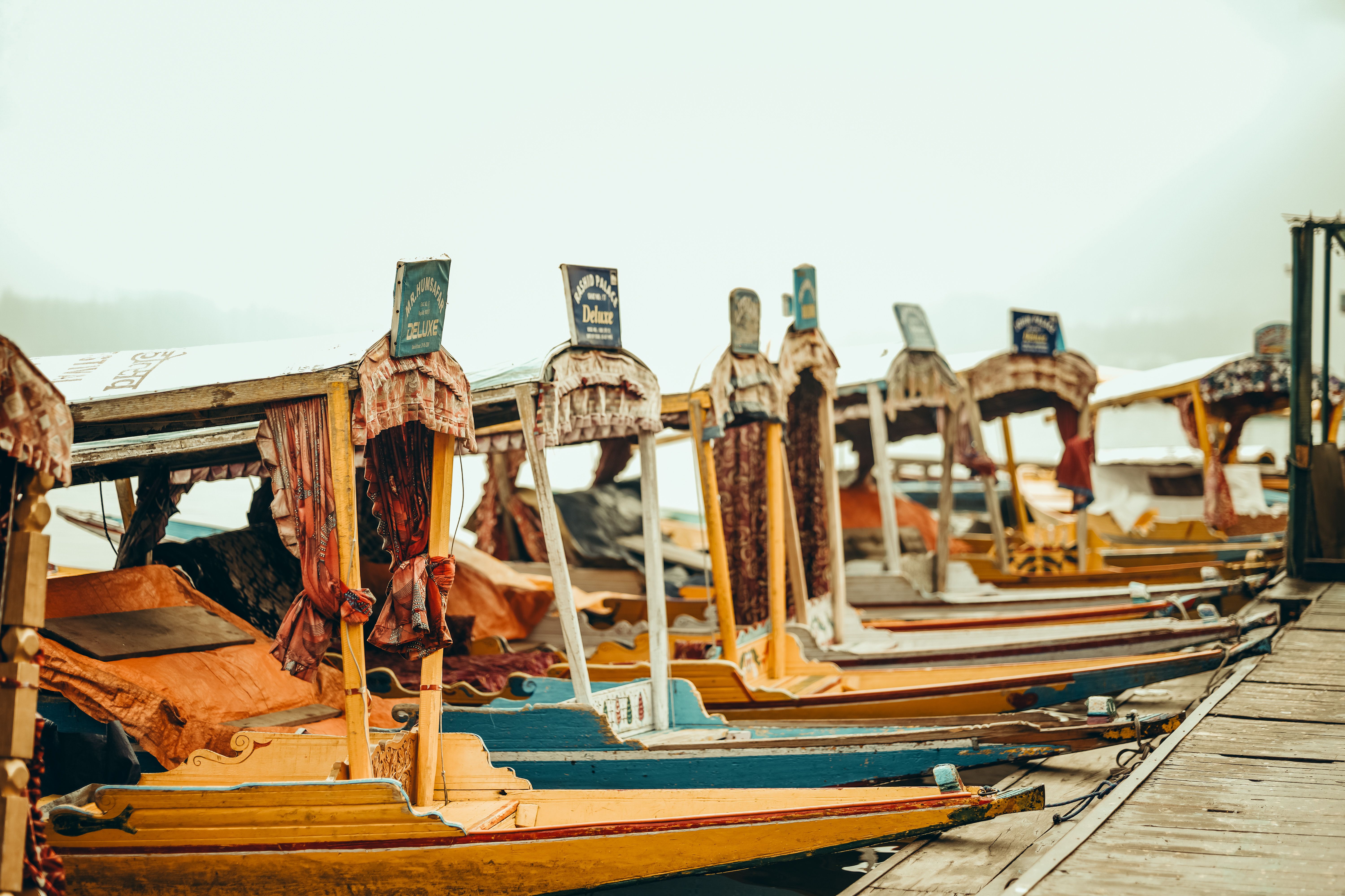 Traditional shikaras on a serene lake reflecting Kashmir heritage