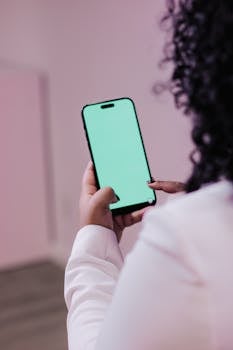 Close-up of an adult using a smartphone with a blank screen indoors, ideal for tech and lifestyle themes.