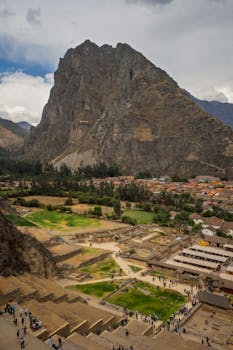 Breathtaking view of the ancient Inca ruins at Ollantaytambo with mountainous backdrop in Cusco, Peru.