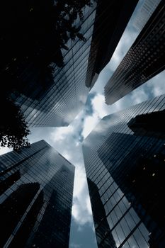 View of Toronto skyscrapers from below with dramatic cloud-filled sky, capturing modern architecture.