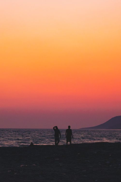 Free Silhouettes during a vibrant sunset over the sea at Muğla, Türkiye. Stock Photo