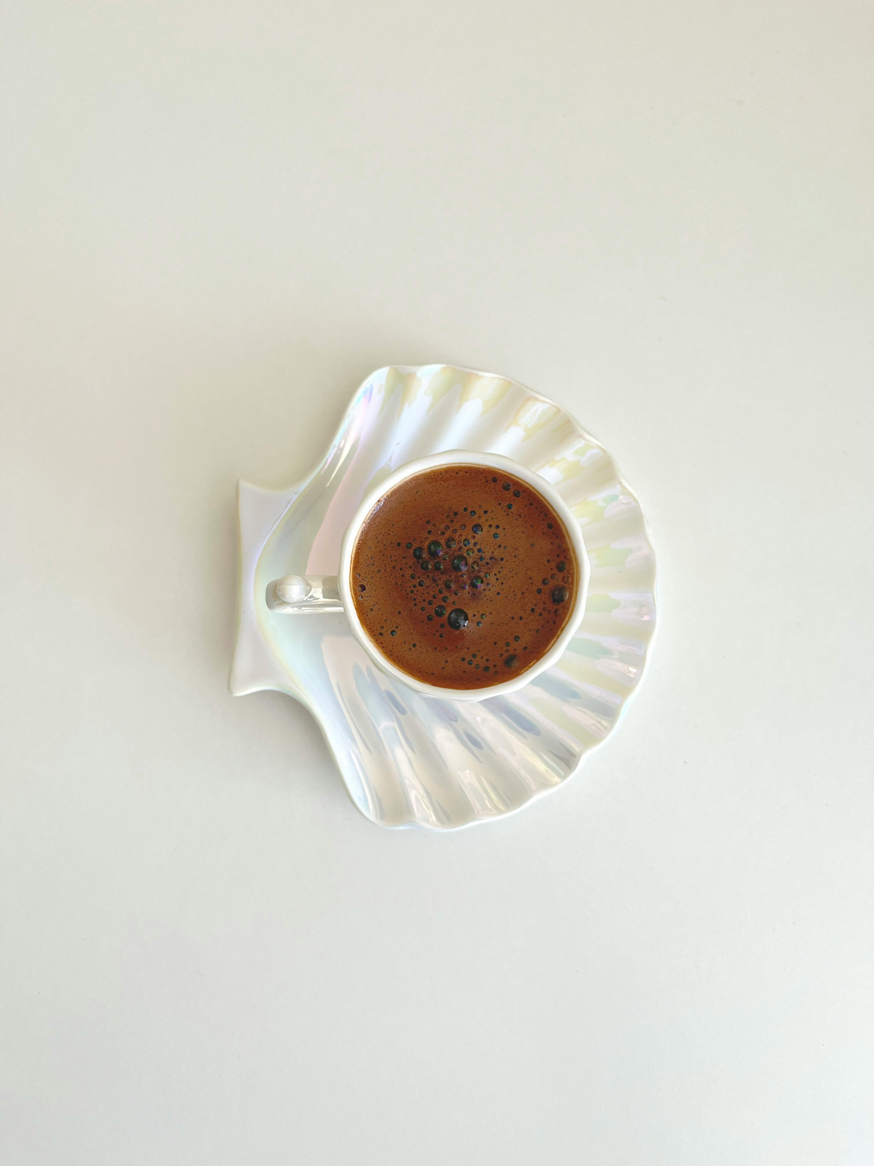 Gratis Tampilan atas kopi Turki dalam tatakan berbentuk kerang yang elegan, membangkitkan kesederhanaan dan keanggunan. Foto Stok