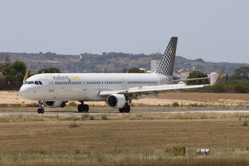 Free Vueling Airlines plane taxiing on the runway during daylight at a summer airport. Stock Photo