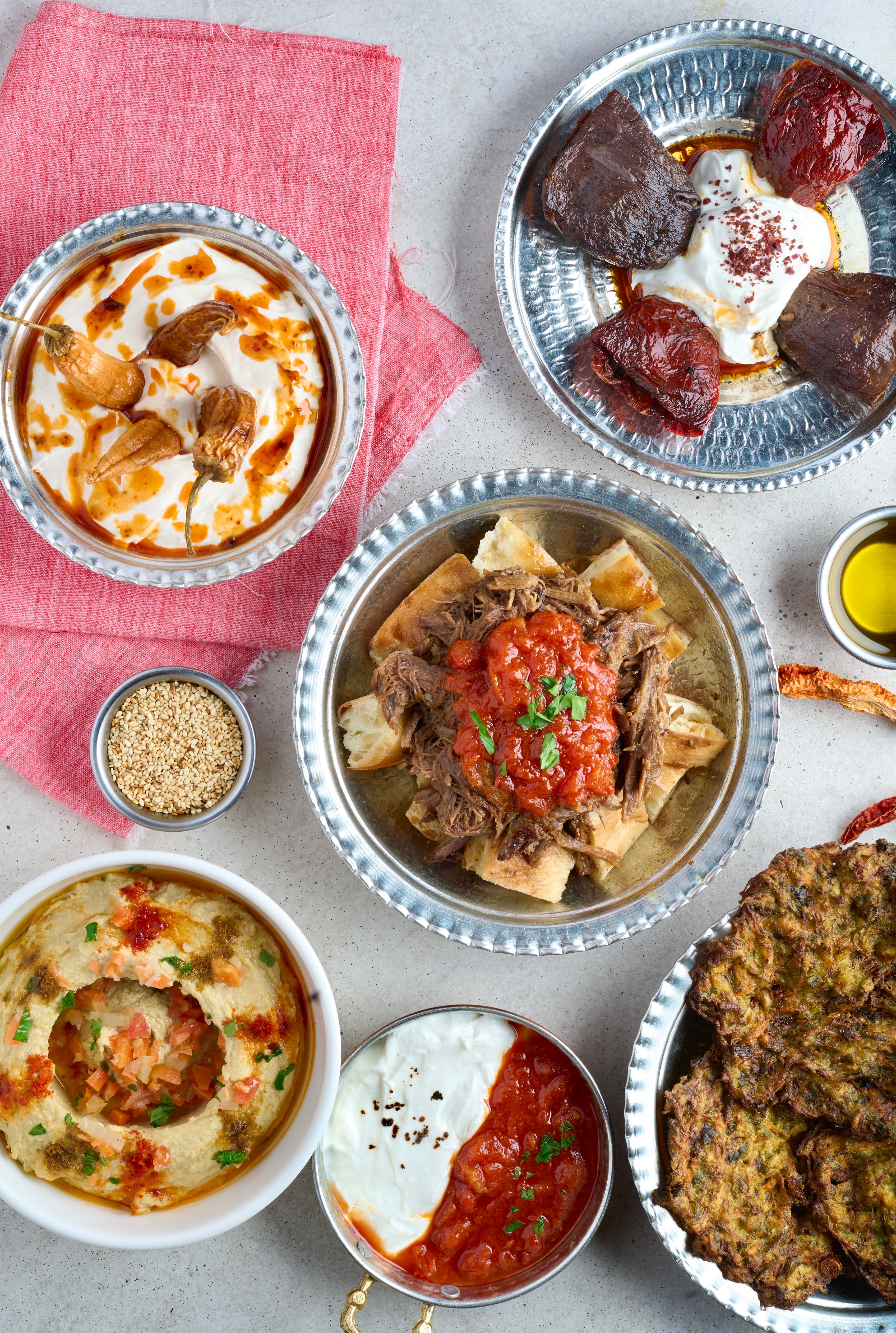 Delicious variety of Middle Eastern dishes featuring hummus, roasted meats, and sauces.