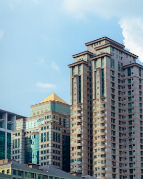 Capture of modern high-rise buildings against a clear blue sky in an urban setting.