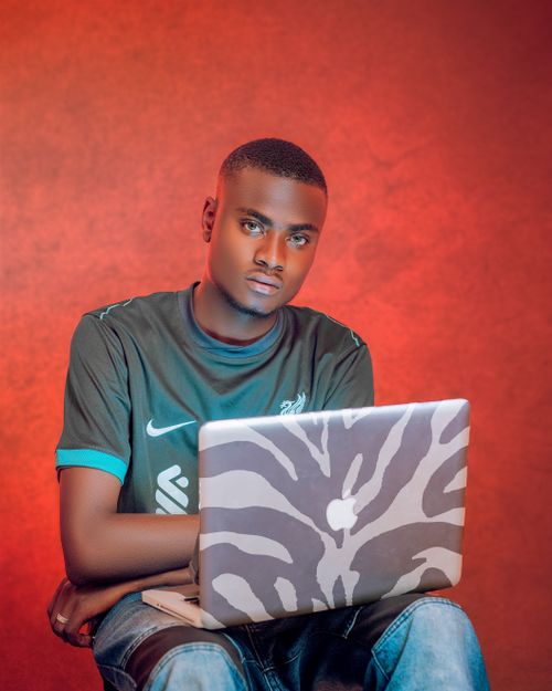 Free Young man sitting in a vibrant room working on a zebra-patterned laptop. Stock Photo