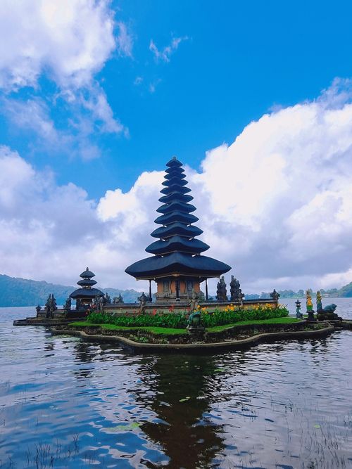 Free Ulun Danu Beratan Temple reflecting on Lake Beratan with a vibrant sky in Bali, Indonesia. Stock Photo