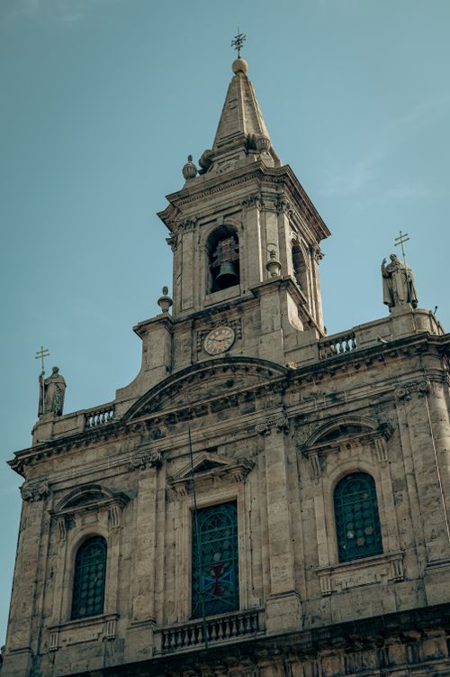 Free Close-up of a historic church tower with intricate stonework against a clear sky. Stock Photo