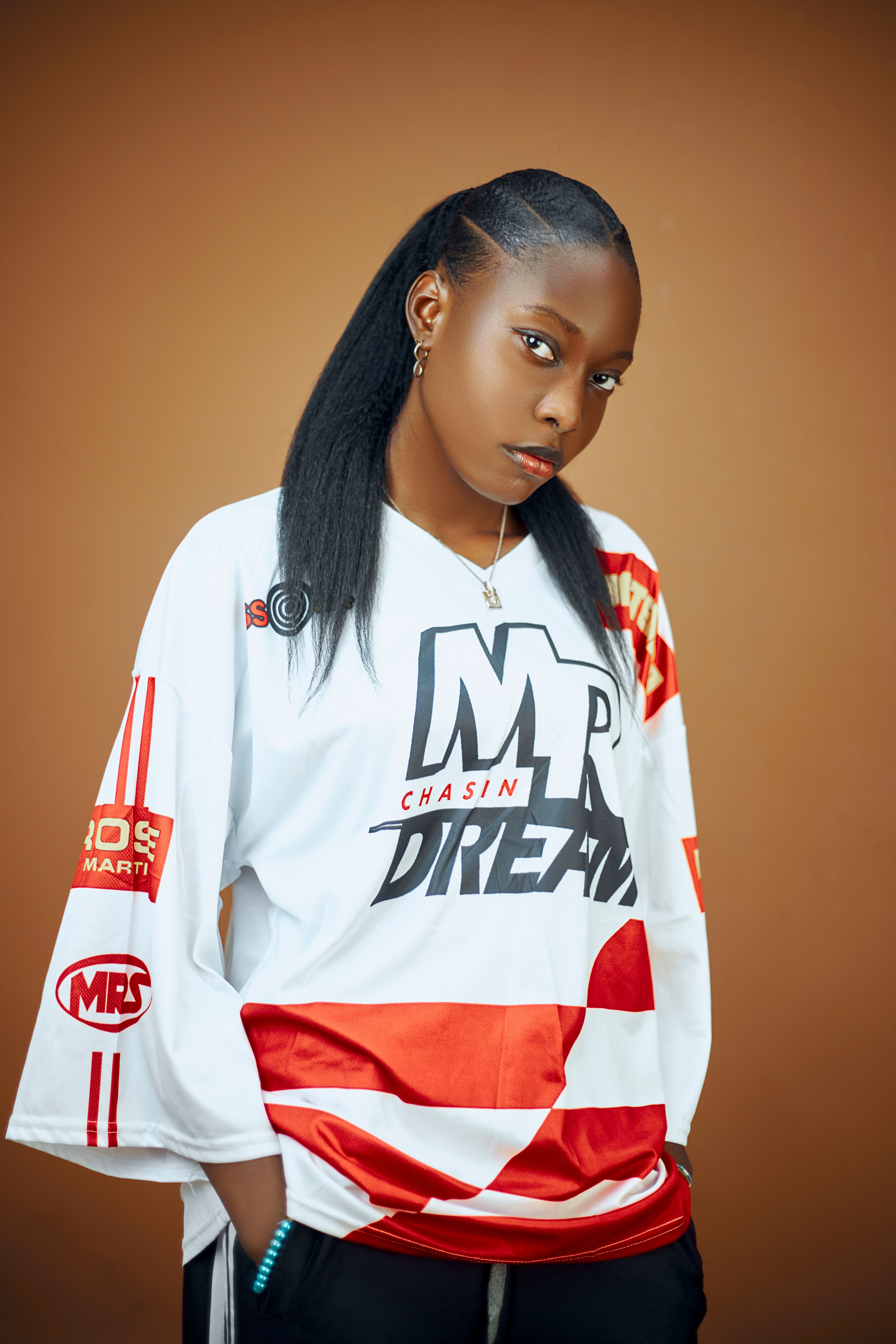 Portrait of a young woman wearing a stylish graphic shirt, standing confidently.