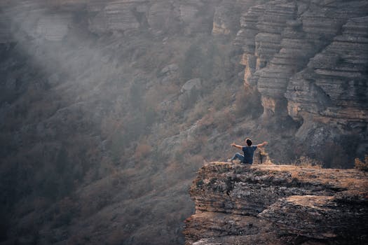 A person sits on a cliff's edge, appreciating Safranbolu's rugged canyon landscape.