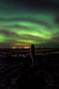 欣赏北极光映照冰岛夜空的女子剪影