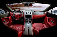 豪华跑车的红色皮革内饰外，是连绵的山脉背景