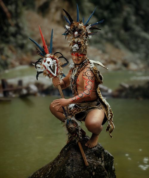 Free Indigenous person in elaborate native attire posing by a river in Tingo María, Perú, showcasing rich cultural heritage. Stock Photo