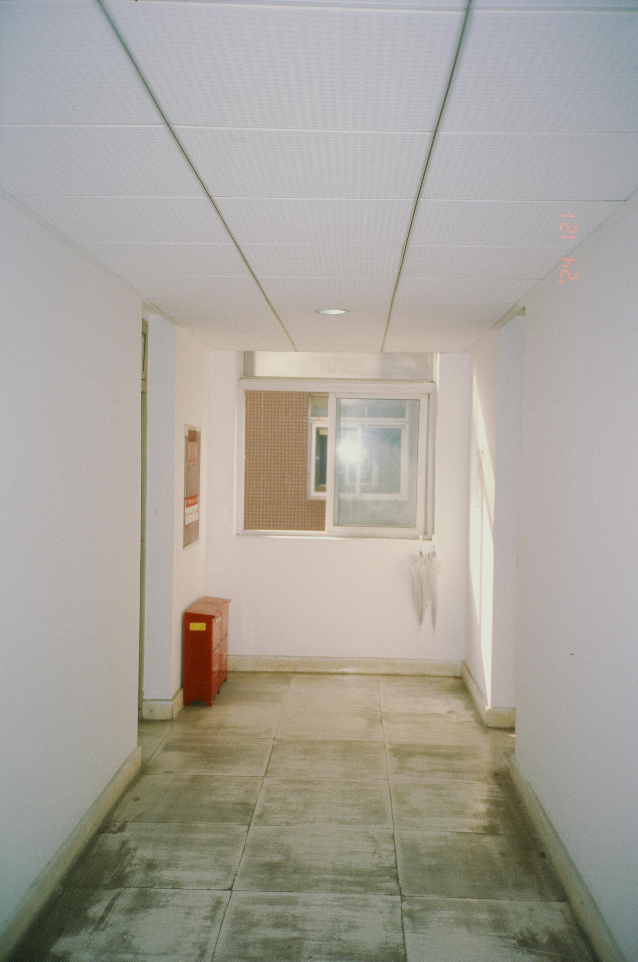 Gratuit Hol minimalist alb, cu o fereastră și o cutie roșie, oferind o iluminare ambientală puternică. Fotografie de stoc