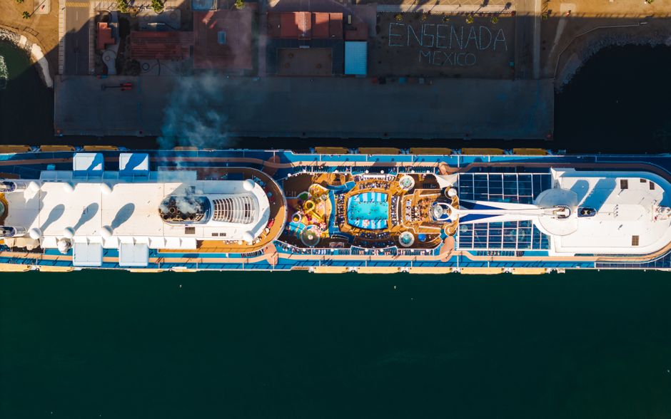 Stunning aerial shot of a cruise ship docked at Ensenada, Mexico, showcasing its pool deck.