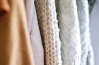 多件羊毛针织毛衣的细节展示，采用柔和中性色调，突出其质感与温暖
