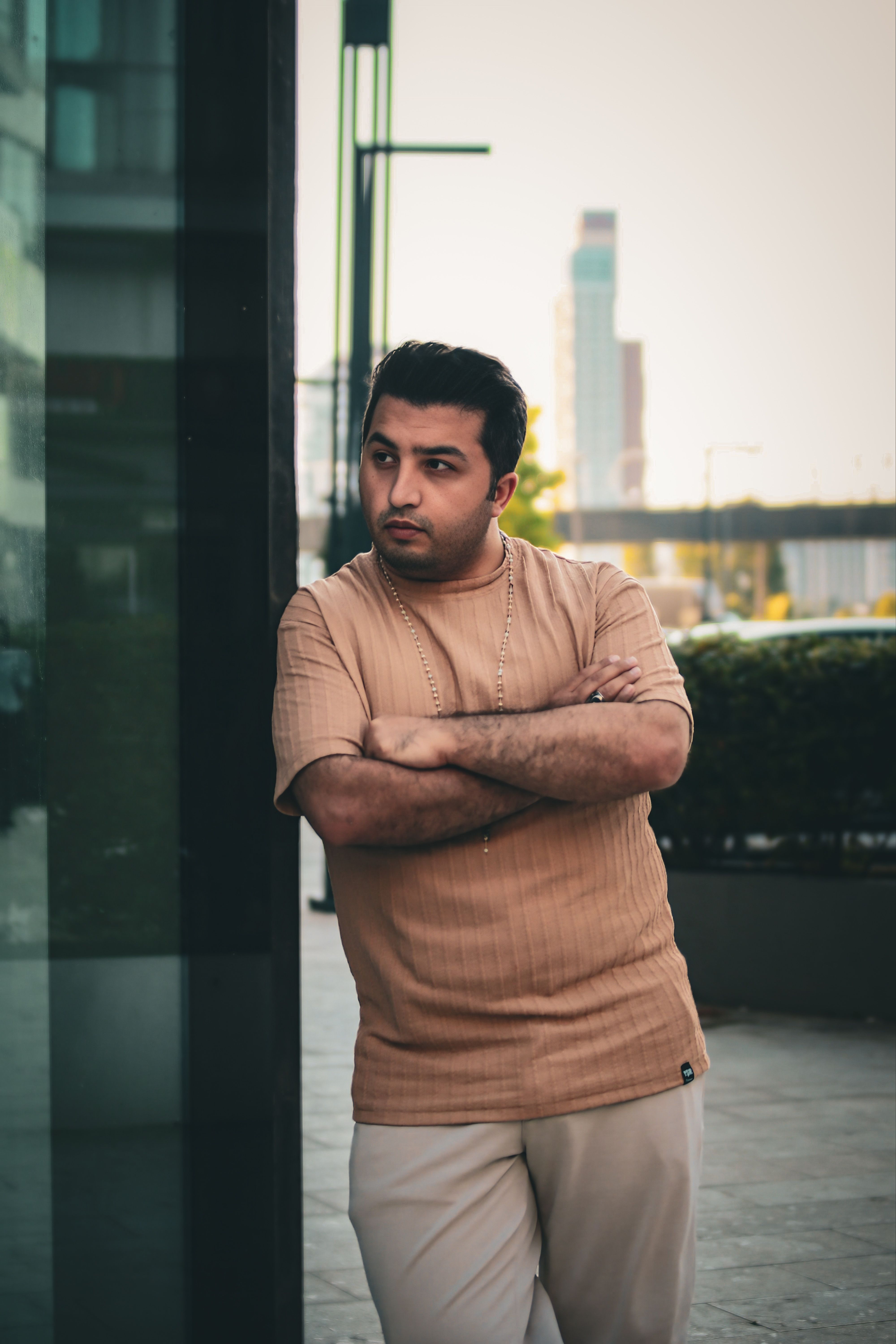 Stylish Man Leaning Against a Glass Building