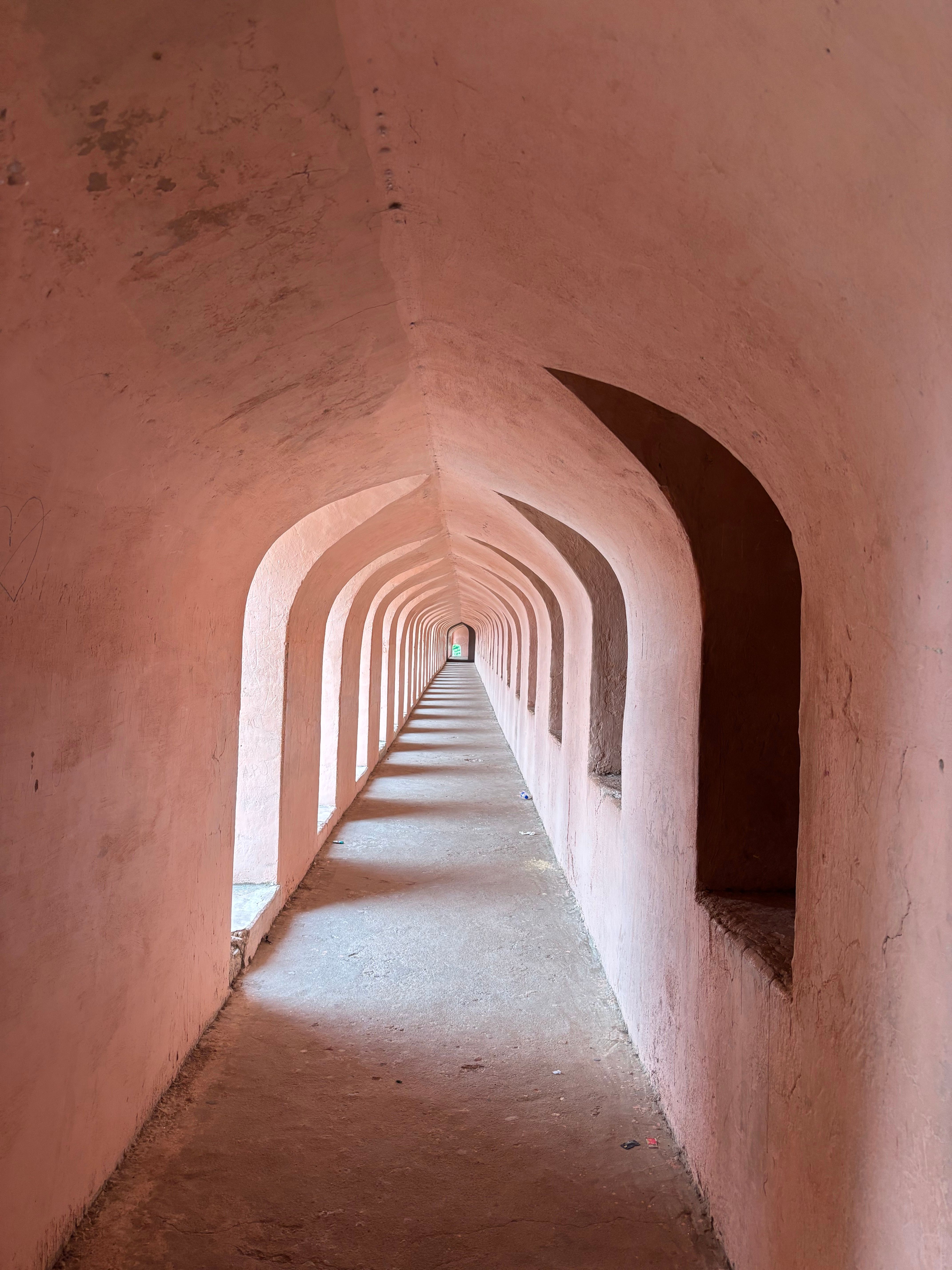 Gratuit Un couloir arqué intemporel présentant l'architecture indienne classique avec des murs et des colonnes roses. Photos