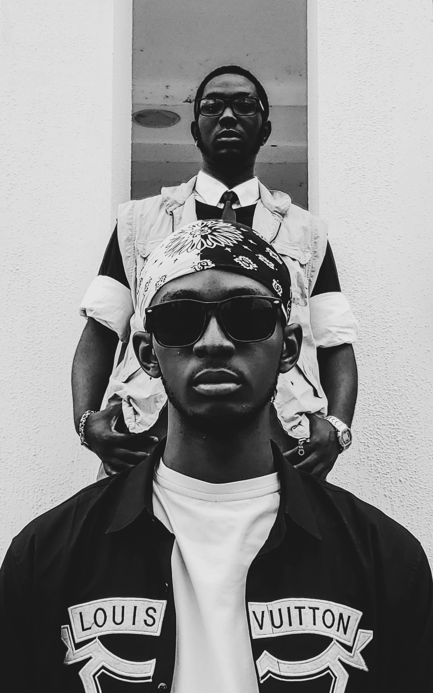 Portrait of two fashionable men in urban attire, exuding confidence and style.