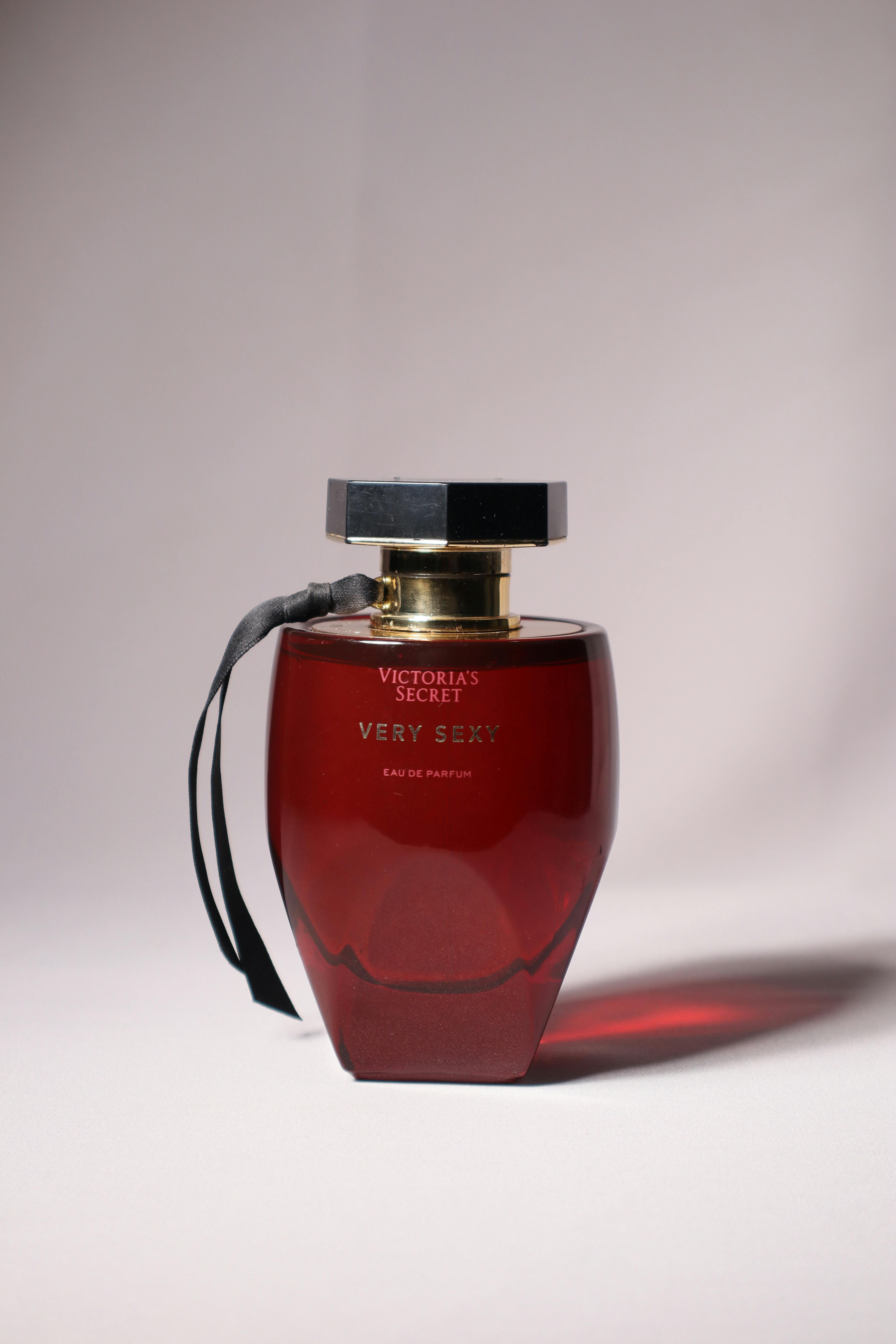 Stylish and elegant red perfume bottle on a neutral backdrop, showcasing luxury and fragrance.