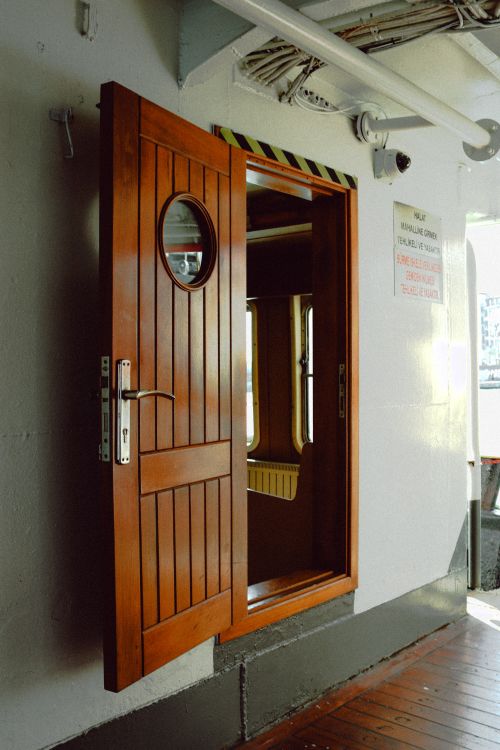 Free Open wooden door with porthole on a ship deck, showing interior. Stock Photo