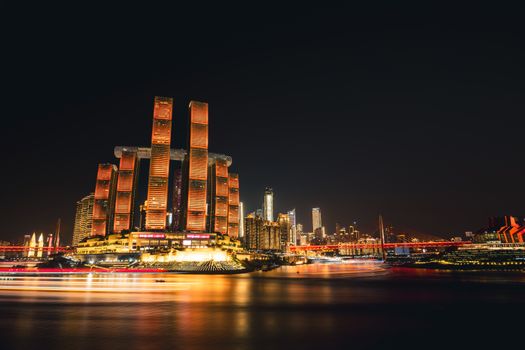 Stunning nightscape of Chongqing's illuminated skyline with iconic architecture reflecting on the river.