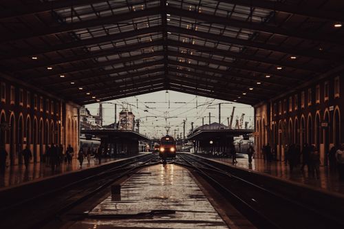 Free Moody urban train station in Lisbon at dusk, capturing an evening commute. Stock Photo