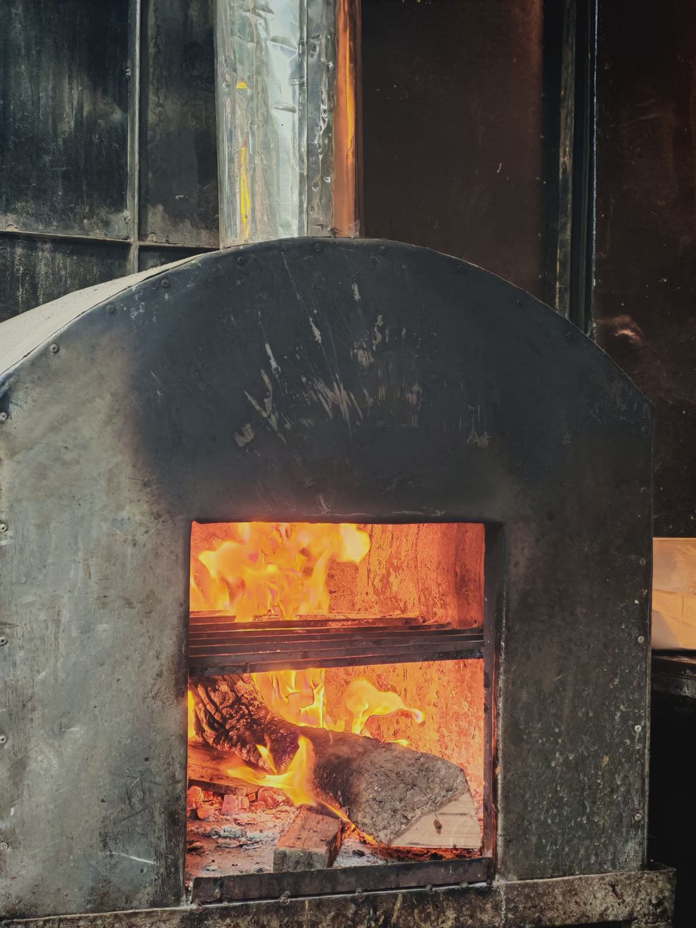 Wood-fired pizza oven glowing with real flames