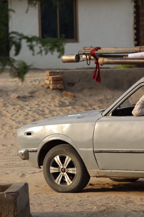 Free A vintage car carrying construction materials in an outdoor setting showcasing practical transportation. Stock Photo