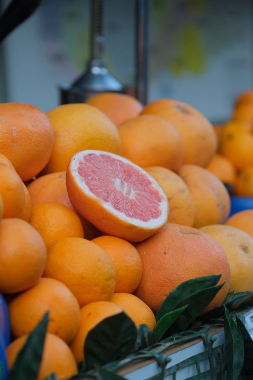 Free A vibrant display of fresh grapefruits and oranges at a market stall, perfect for health and freshness themes. Stock Photo