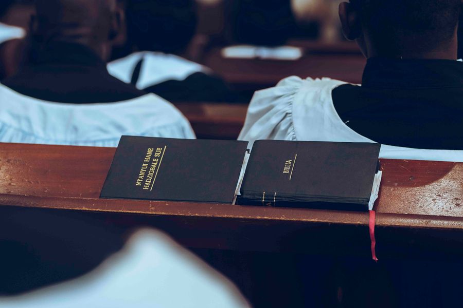 Open Bible and hymn book on a pew