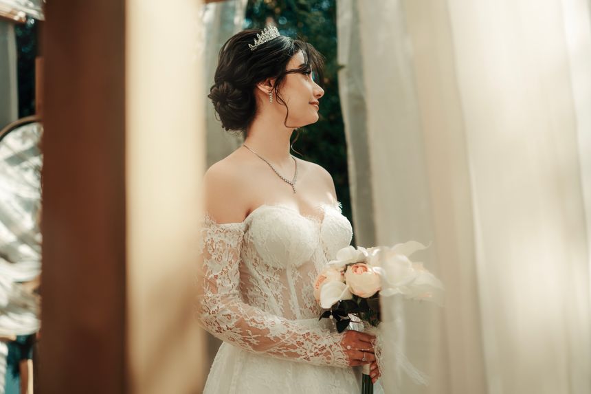Bride in a lace gown holding a bouquet — Wolrider YURTSEVEN on Pexels