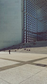 People relaxing near the La Défense arch in Paris, showcasing modern architectural design.